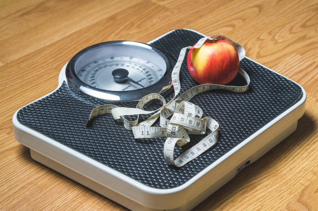 weight scale with tape measure and apple on top