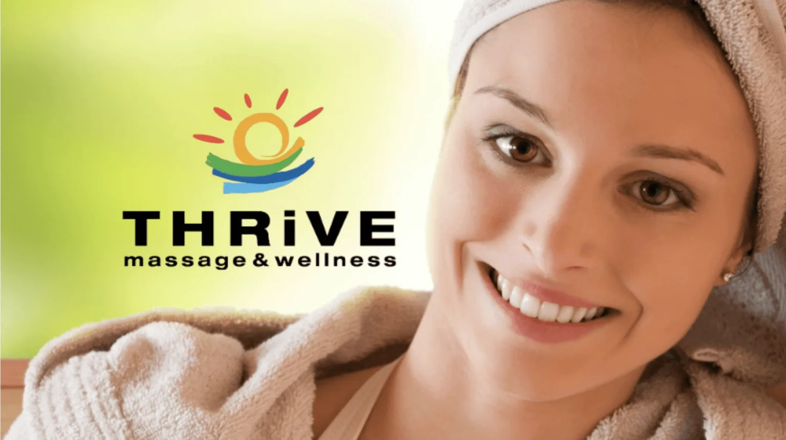 Smiling woman wrapped in a towel beside the Thrive Massage & Wellness logo